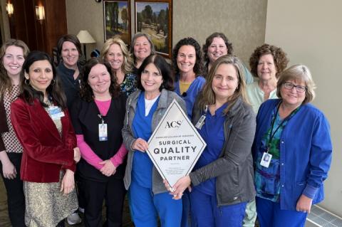 Cancer care staff and providers with recognition plaque.